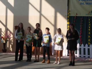 Grupa uczniów trzymająca nagrody i dyplomy w konkursie recytatorskim